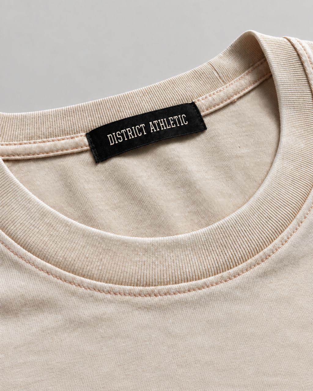 The Potomac Tee in sand with red print, collar and label